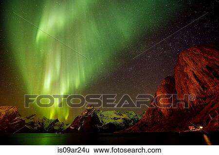 Stock Photograph - "View of aurora borealis over sea and snow capped mountains, Reine, Norway". Fotosearch