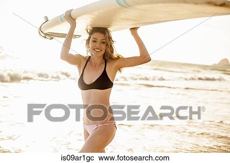 "Woman carrying surfboard on head, Malibu, California, USA" View Large Photo Image Stock Image - "Woman carrying surfboard on head, Malibu, California, USA". Fotosearch