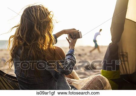 Woman taking photograph on beach View Large Photo Image Stock Image - Woman taking photograph on beach. Fotosearch