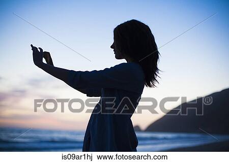 "Woman taking selfie on beach at sunset, Malibu, California, USA" View Large Photo Image Stock Image - "Woman taking selfie on beach at sunset, Malibu, California, USA". Fotosearch