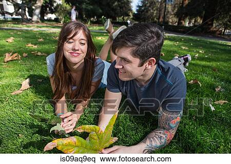 Young couple lying in park with autumn leaf View Large Photo Image Stock Photography - Young couple lying in park with autumn leaf. Fotosearch