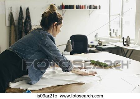 Young female seamstress laying out pattern component in fashion studio View Large Photo Image Picture - Young female seamstress laying out pattern component in fashion studio. Fotosearch