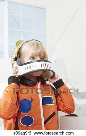 Stock Image - "Young girl playing dress up, wearing astronaut outfit". Fotosearch