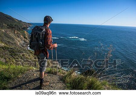"Young male hiker looking out from cliff top, Big Sur, California, USA" View Large Photo Image Picture - "Young male hiker looking out from cliff top, Big Sur, California, USA". Fotosearch