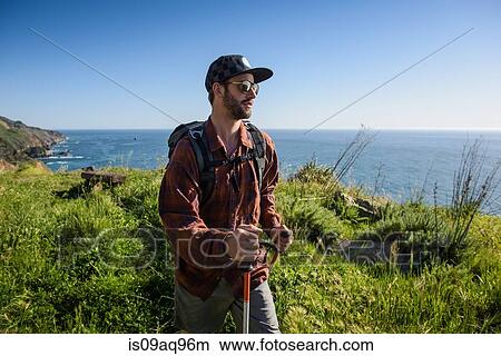 Picture - "Young male hiker on cliff top path, Big Sur, California, USA". Fotosearch