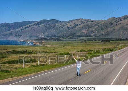 "Young man with arms raised on coastal highway, Big Sur, California, USA" View Large Photo Image Stock Photography - "Young man with arms raised on coastal highway, Big Sur, California, USA". Fotosearch