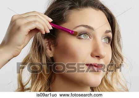 Young woman applying eyeshadow View Large Photo Image Picture - Young woman applying eyeshadow. Fotosearch