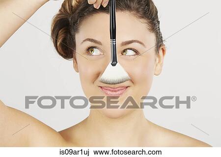 Young woman holding make-up brush View Large Photo Image Stock Image - Young woman holding make-up brush. Fotosearch