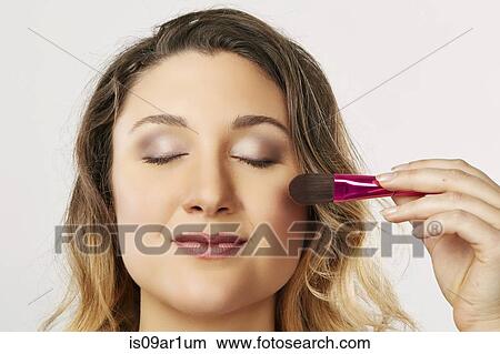 Young woman using blusher brush View Large Photo Image Picture - Young woman using blusher brush. Fotosearch