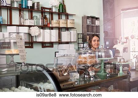 Bakery owner standing behind counter of vegan, allergy-friendly bakery View Large Photo Image Stock Photo - Bakery owner standing behind counter of vegan, allergy-friendly bakery. Fotosearch