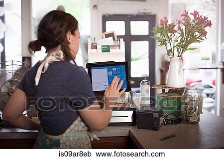 Bakery owner using cash register at counter View Large Photo Image Stock Image - Bakery owner using cash register at counter. Fotosearch