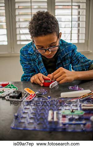 Stock Photography - Boy working on science project at home. Fotosearch