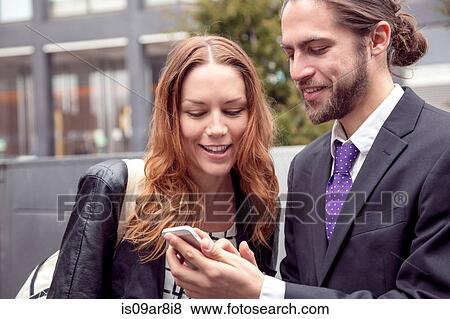 Business people sharing information on smartphone, New York, USA View Large Photo Image Stock Photo - Business people sharing information on smartphone, New York, USA. Fotosearch