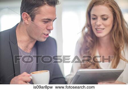 Stock Photo - Business people using digital tablet at business lunch. Fotosearch