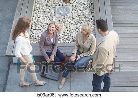 Stock Photograph -  Businessman and businesswomen having informal meeting on hotel terrace. Fotosearch