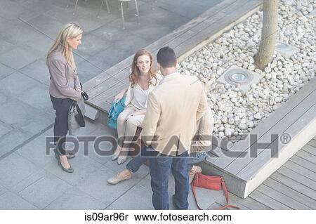 Stock Photography -  Businessman and women meeting informally on hotel terrace. Fotosearch