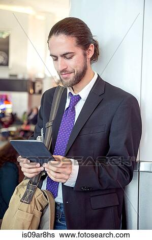 Stock Photograph - Businessman on business trip using digital tablet, New York, USA. Fotosearch