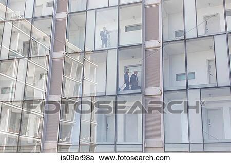 Businessmen and woman in corridors of glass fronted hotel View Large Photo Image Stock Image - Businessmen and woman in corridors of glass fronted hotel. Fotosearch