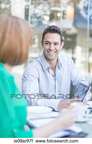 Stock Image - Businesswoman and man meeting at coffee break on hotel terrace. Fotosearch