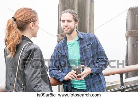Stock Image - Couple on seafront, New York, New York, USA. Fotosearch