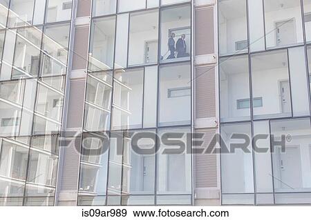 Detail of businessman and woman walking on corridor of glass fronted hotel View Large Photo Image Stock Photo - Detail of businessman and woman walking on corridor of glass fronted hotel. Fotosearch