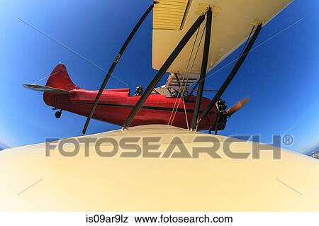 Elevated wide angle view of bi-plane wing and pilot in flight View Large Photo Image Stock Photo - Elevated wide angle view of bi-plane wing and pilot in flight. Fotosearch