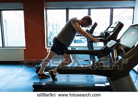 Exhausted mid adult man leaning forward on gym treadmill View Large Photo Image Stock Image - Exhausted mid adult man leaning forward on gym treadmill. Fotosearch