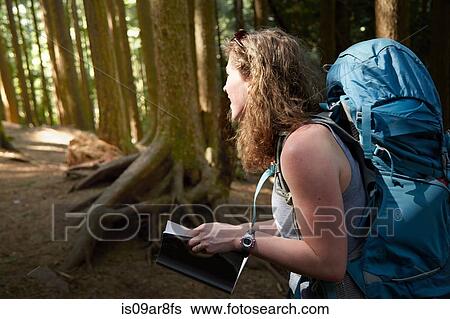 Stock Photograph - Female backpacker hiking in woods. Fotosearch