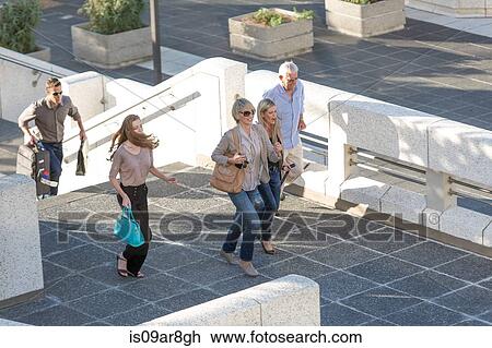 Five adults walking across elevated walkway View Large Photo Image Stock Image - Five adults walking across elevated walkway. Fotosearch