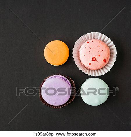 Four macarons against black background, overhead view View Large Photo Image Stock Photography - Four macarons against black background, overhead view. Fotosearch