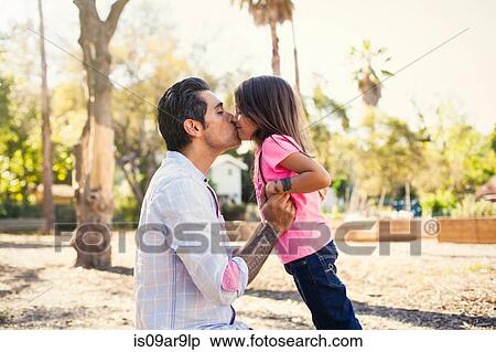 Stock Photography - Girl kissing father in community garden. Fotosearch