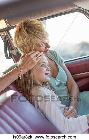Grandmother and granddaughter sitting in back seat of car, smiling View Large Photo Image Stock Image - Grandmother and granddaughter sitting in back seat of car, smiling. Fotosearch