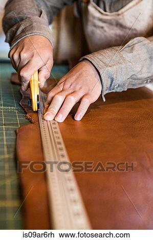 Hands of leather craftsman using rotary cutter on workshop bench View Large Photo Image Stock Image - Hands of leather craftsman using rotary cutter on workshop bench. Fotosearch