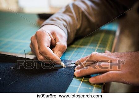 Hands of tailor marking fabric with chalk on workshop bench View Large Photo Image Stock Photography - Hands of tailor marking fabric with chalk on workshop bench. Fotosearch