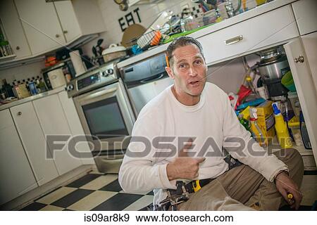 Handyman fixing kitchen sink pipe View Large Photo Image Stock Photo - Handyman fixing kitchen sink pipe. Fotosearch