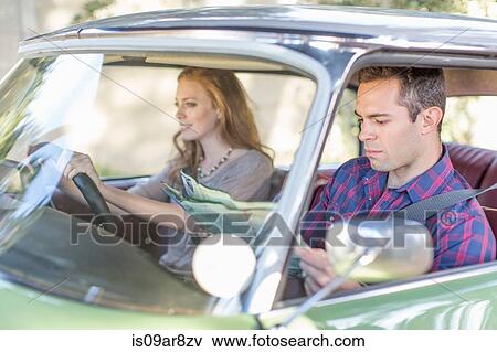 Heterosexual couple in car together, looking lost View Large Photo Image Stock Photo - Heterosexual couple in car together, looking lost. Fotosearch
