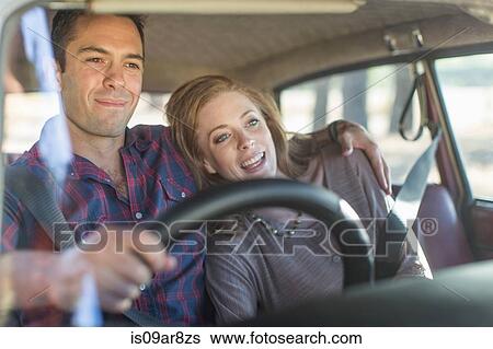 Stock Photograph - Heterosexual couple in car together, smiling. Fotosearch