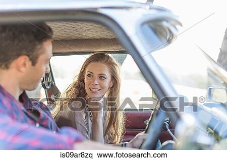 Stock Photography - Heterosexual couple in car together, smiling. Fotosearch