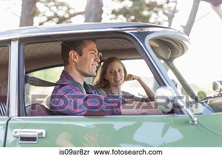 Stock Photography - Heterosexual couple in car together, smiling. Fotosearch