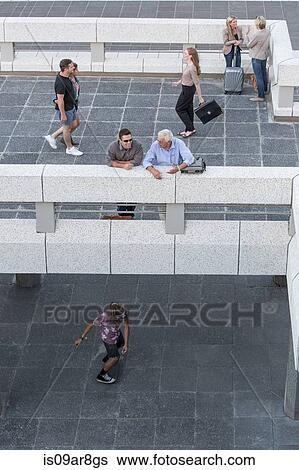 Stock Photograph - High angle view of elevated walkway, people standing talking. Fotosearch