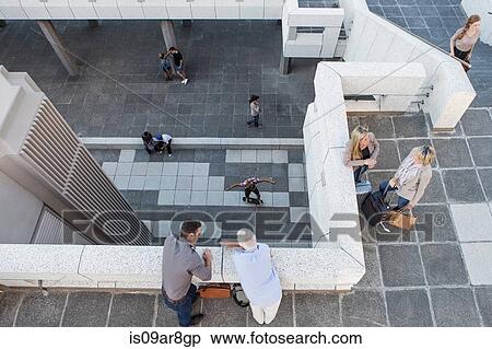 Stock Photography - High angle view of elevated walkway, people standing talking. Fotosearch