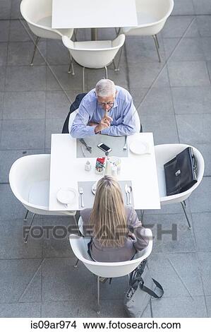 High angle view of senior businessman and woman talking at table on hotel terrace View Large Photo Image Picture - High angle view of senior businessman and woman talking at table on hotel terrace. Fotosearch