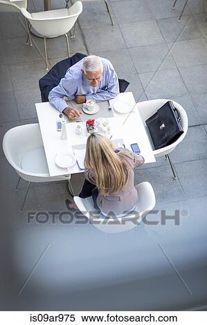 High angle view of senior businessman and woman sitting at table on hotel terrace View Large Photo Image Stock Photography - High angle view of senior businessman and woman sitting at table on hotel terrace. Fotosearch