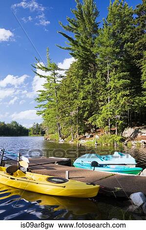 Kayaks and paddle boat tied to dock on lake, Quebec, Canada View Large Photo Image Stock Photo - Kayaks and paddle boat tied to dock on lake, Quebec, Canada. Fotosearch
