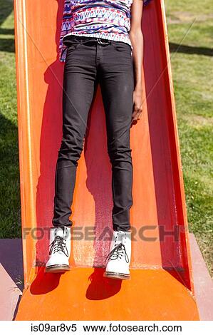 Legs and white boots of young man on orange playground slide View Large Photo Image Stock Photography - Legs and white boots of young man on orange playground slide. Fotosearch