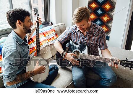 Male couple at home, play guitar and banjo, laughing View Large Photo Image Stock Image - Male couple at home, play guitar and banjo, laughing. Fotosearch