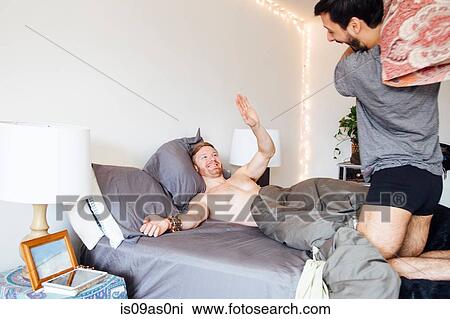 Male couple having pillow fight, laughing View Large Photo Image Stock Image - Male couple having pillow fight, laughing. Fotosearch