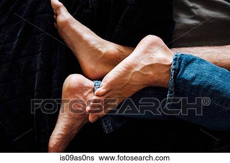 Stock Photograph - Male couple lying together, focus on feet. Fotosearch