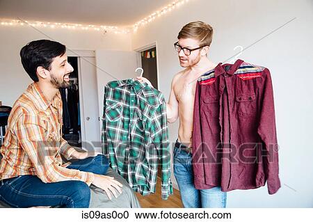 Male couple, mid adult man asking for help choosing shirt View Large Photo Image Stock Image - Male couple, mid adult man asking for help choosing shirt. Fotosearch