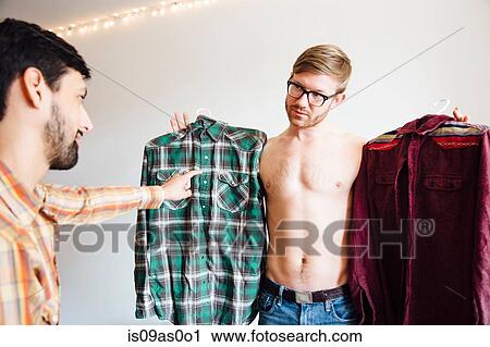Male couple, mid adult man asking for help choosing shirt View Large Photo Image Stock Image - Male couple, mid adult man asking for help choosing shirt. Fotosearch